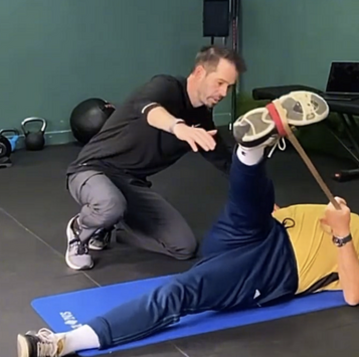 Jonny coaching a golfer through an individual mobility exercise